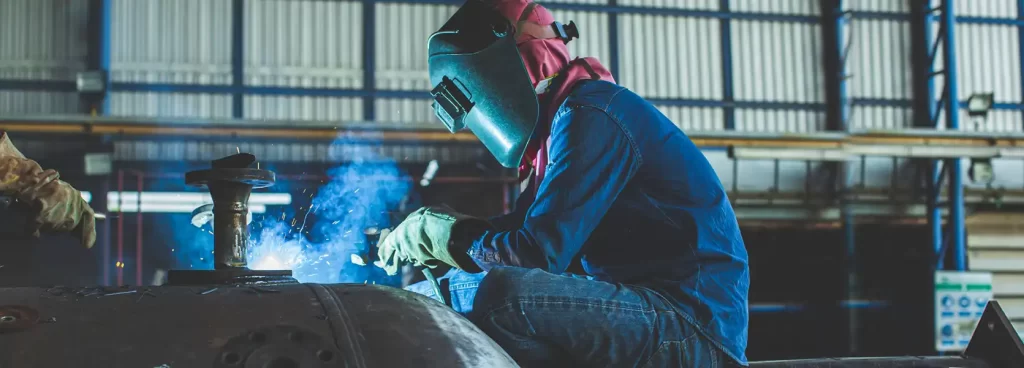 Welder working on a metal structure with sparks flying