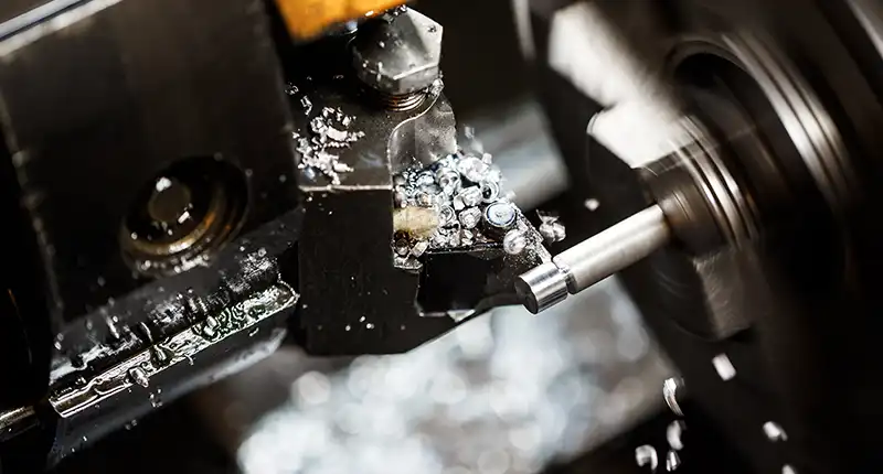 A close-up shot of a hybrid 3D printer/CNC machine head, showing both additive and subtractive processes.