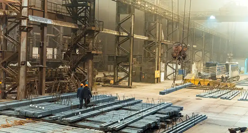 A detailed shot of a complex steel beam connection or framework on a active Dubai construction site. Showcases strength and precision.
